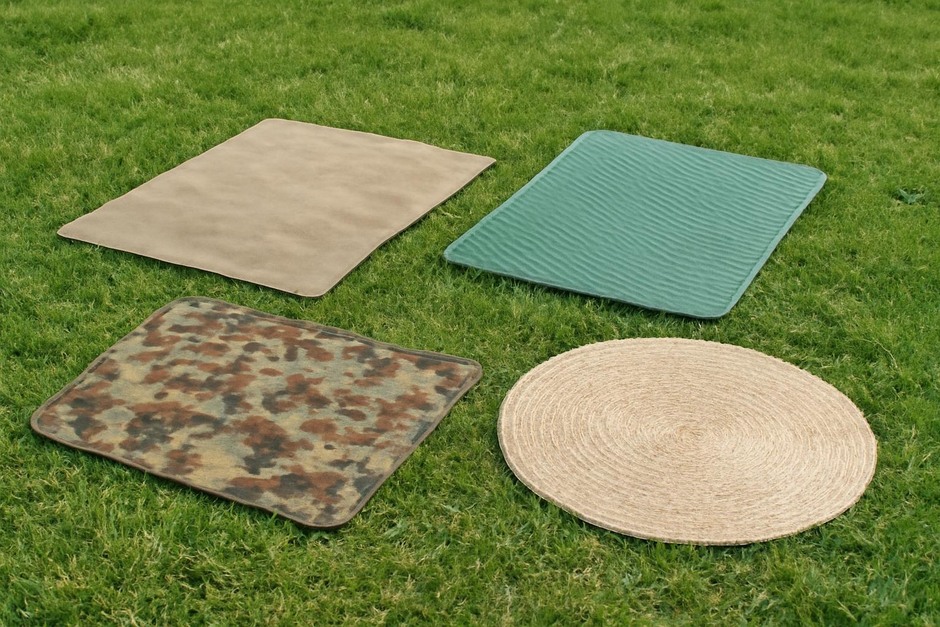 A selection of portable ground coverings laid out on grass